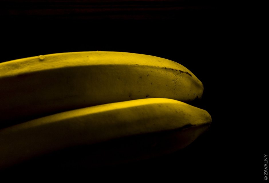 Черный банан на желтом фоне